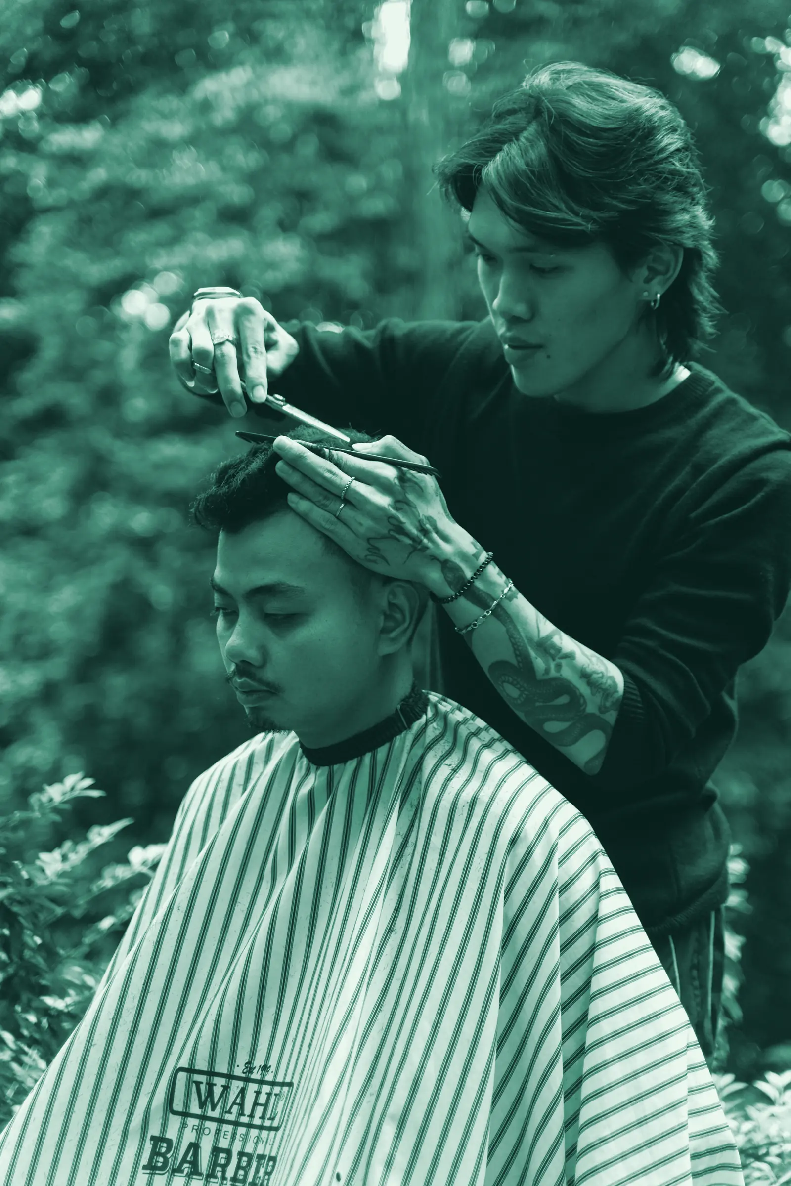 Illustrative photo: a barber cutting a client's hair outdoors.