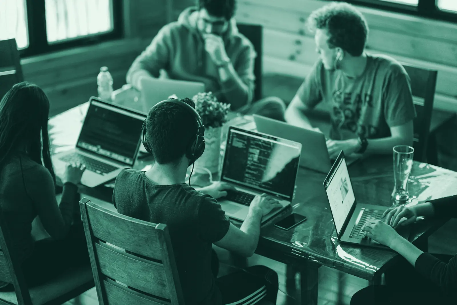 Illustrative photo: a team working on laptops around a shared table.